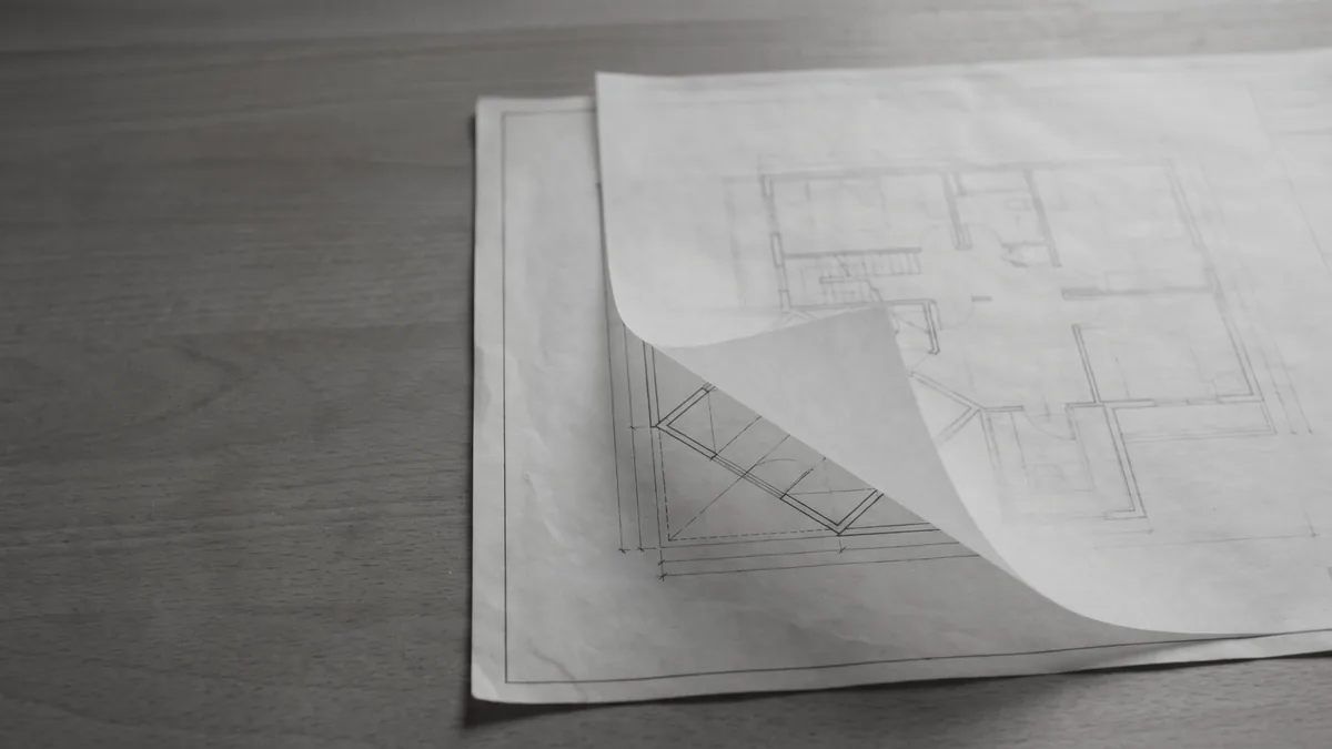 Tracing paper lifted over a printed drawing